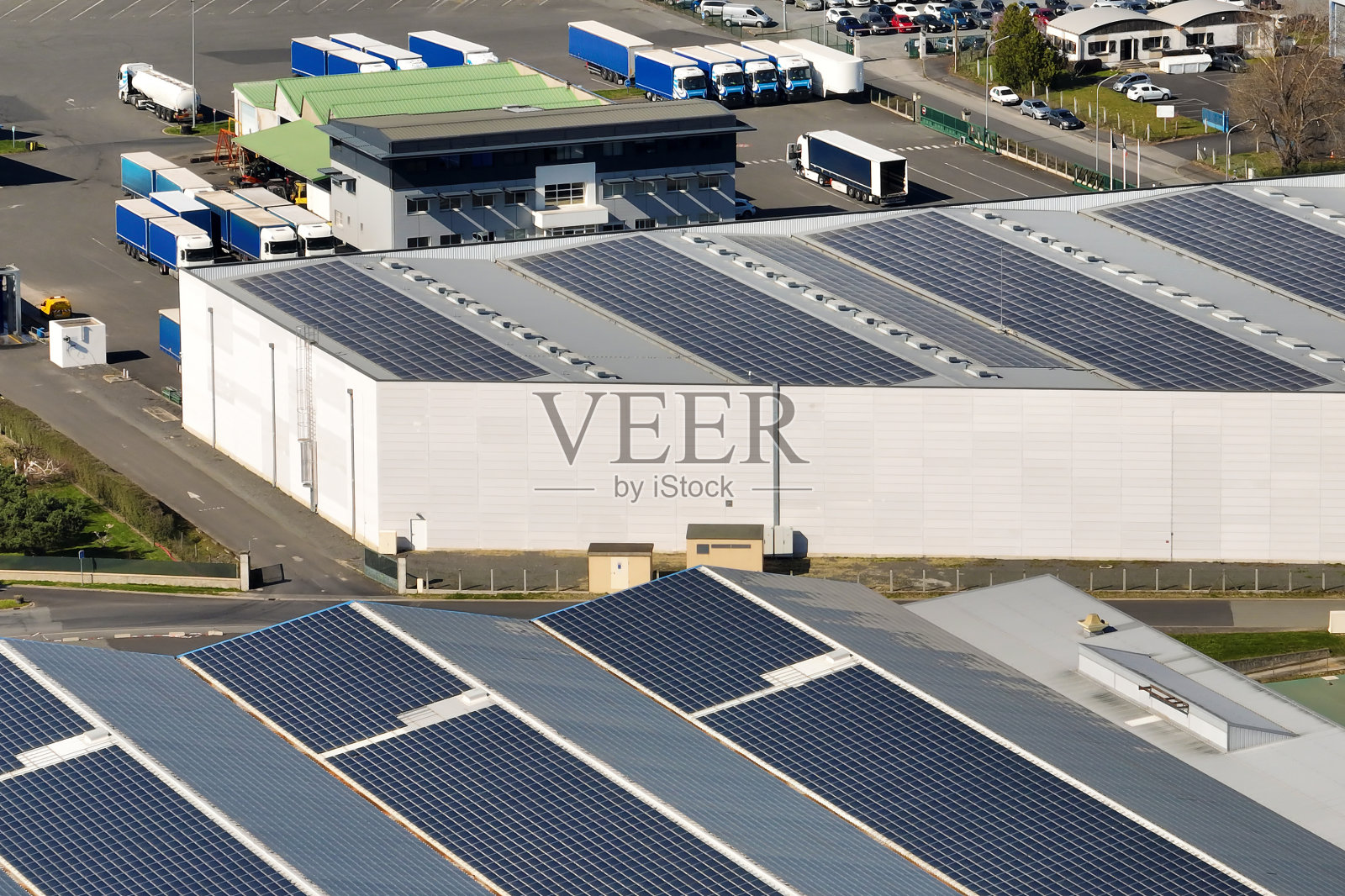 工业建筑屋顶安装蓝色光伏板，生产绿色生态电力的太阳能电站鸟瞰图。生产可持续能源的理念照片摄影图片