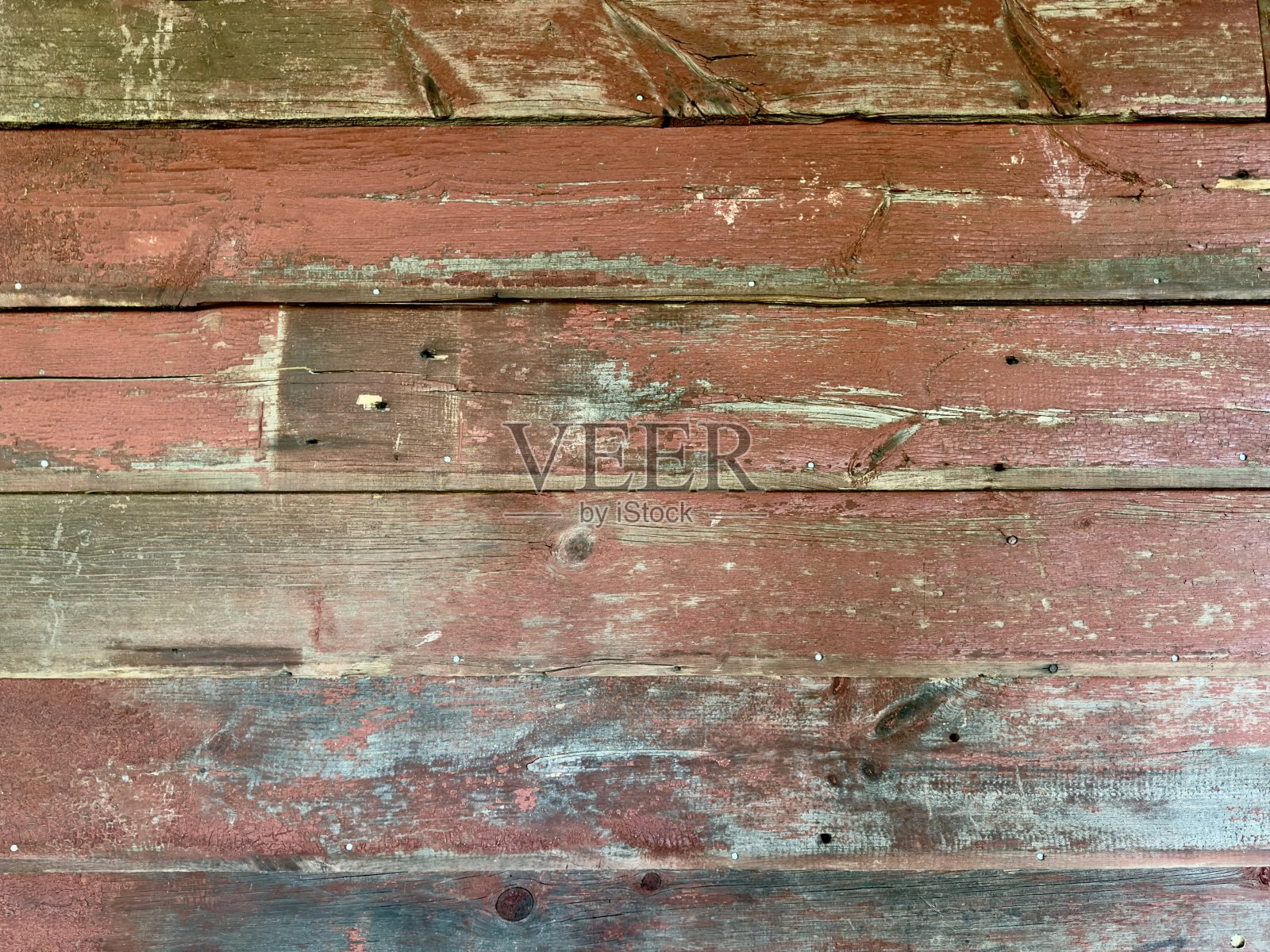 饱经风霜的旧红色谷仓木墙，褪去的油漆和粗糙的纹理，散发着乡村的魅力，讲述着过去的故事，为乡村景观增添了个性。照片摄影图片