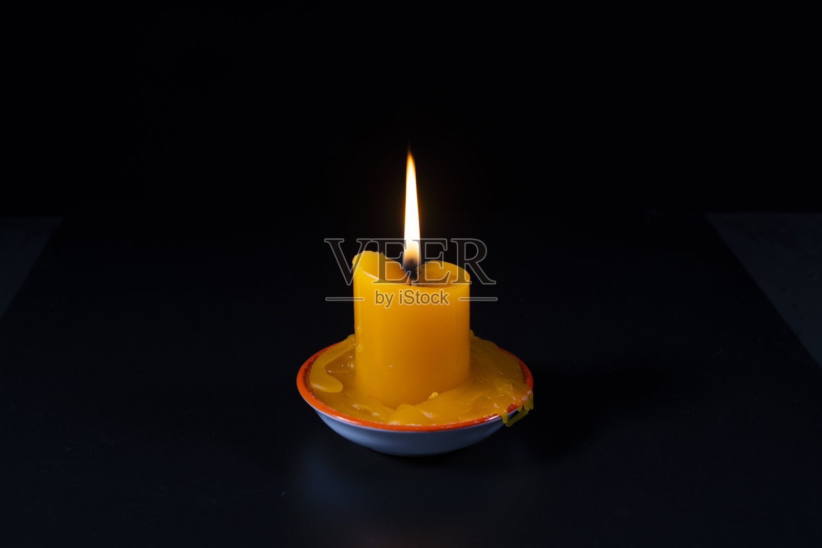 一个明亮的蜡烛在黑暗中燃烧的特写镜头照片摄影图片