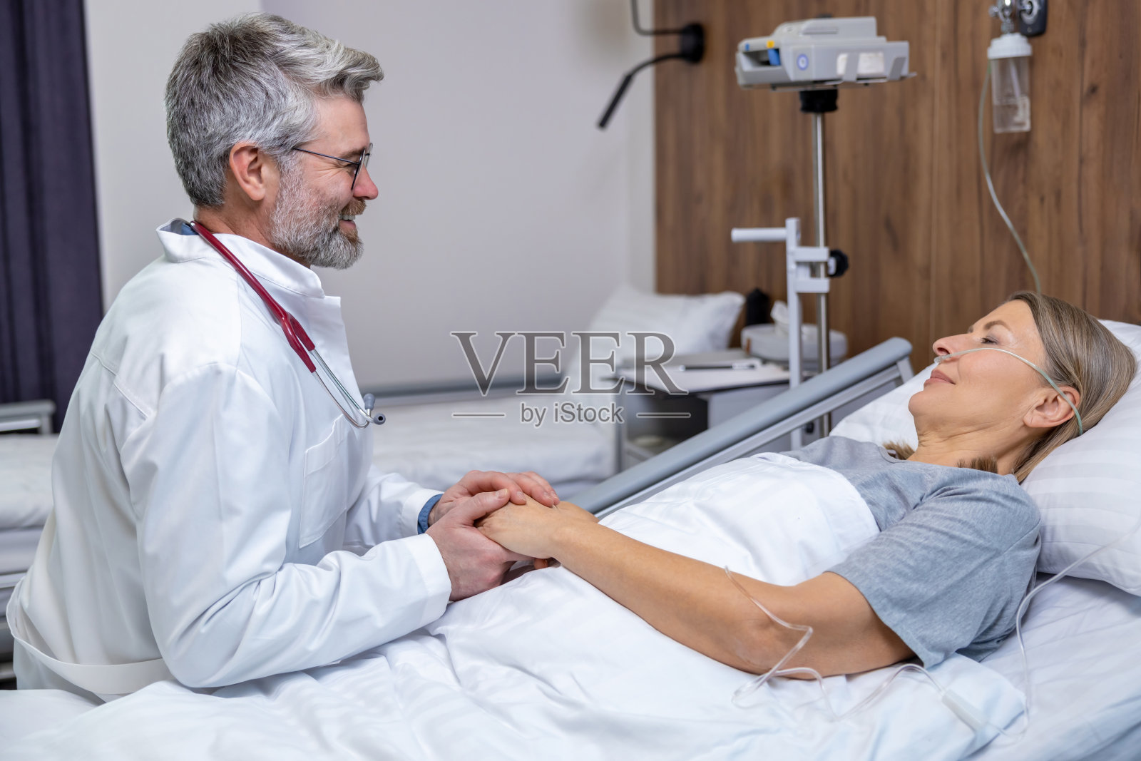 在重症监护室里，男医生正在支持一位女病人照片摄影图片