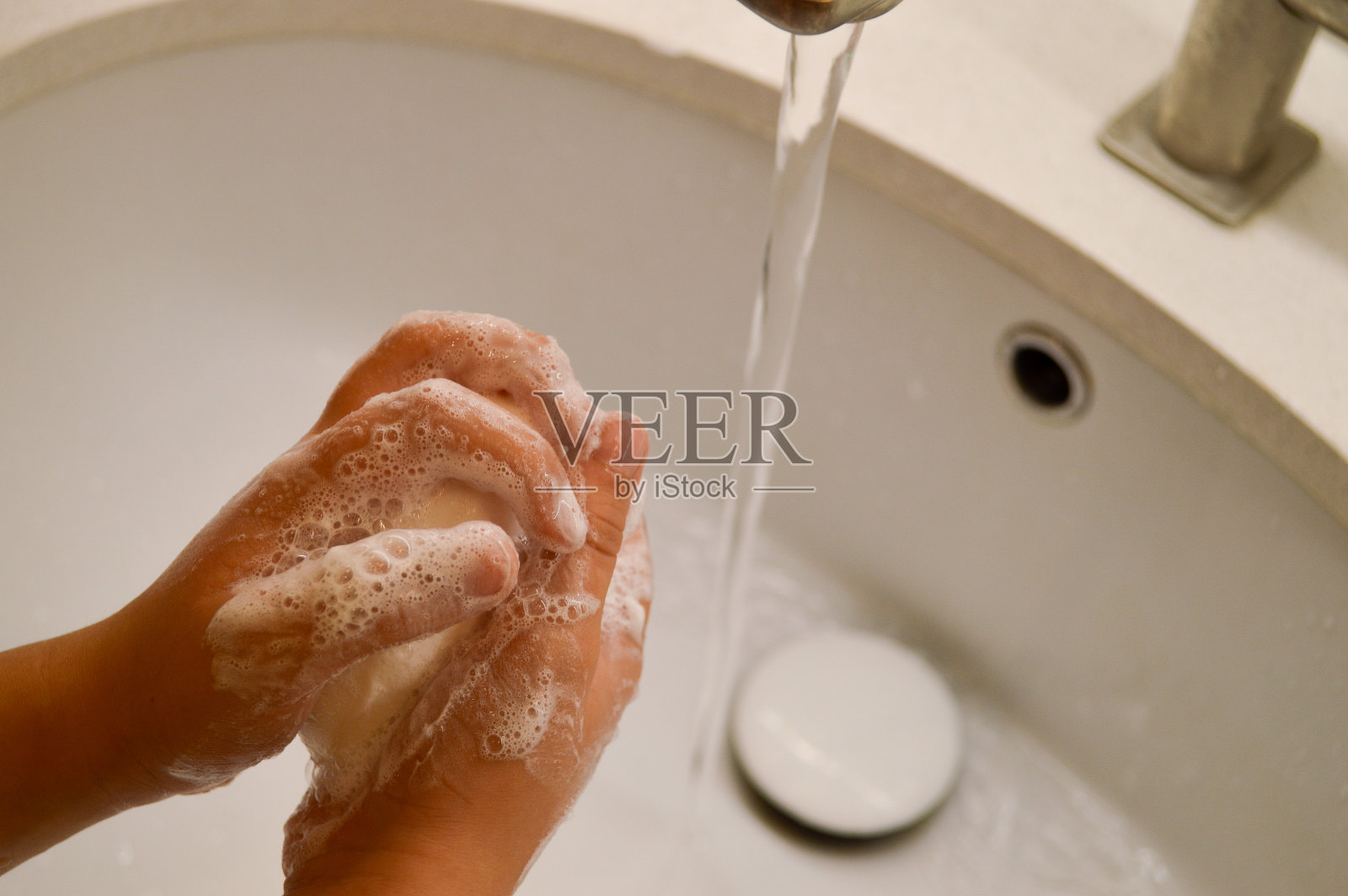 水龙头下用肥皂洗手，儿童卫生。照片摄影图片
