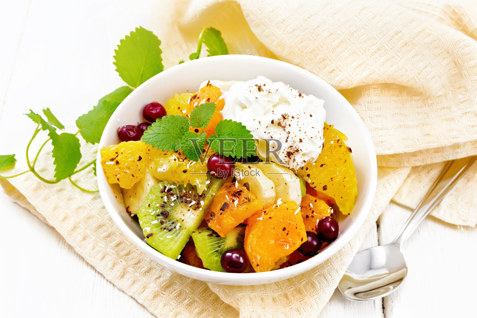 沙拉水果，蔓越莓和奶油放在碗里，放在白板上照片摄影图片