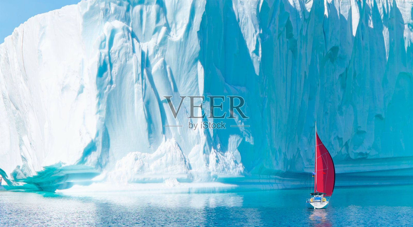 库鲁苏克附近的巨大冰山和单独的红帆游艇-格陵兰岛，东格陵兰岛照片摄影图片