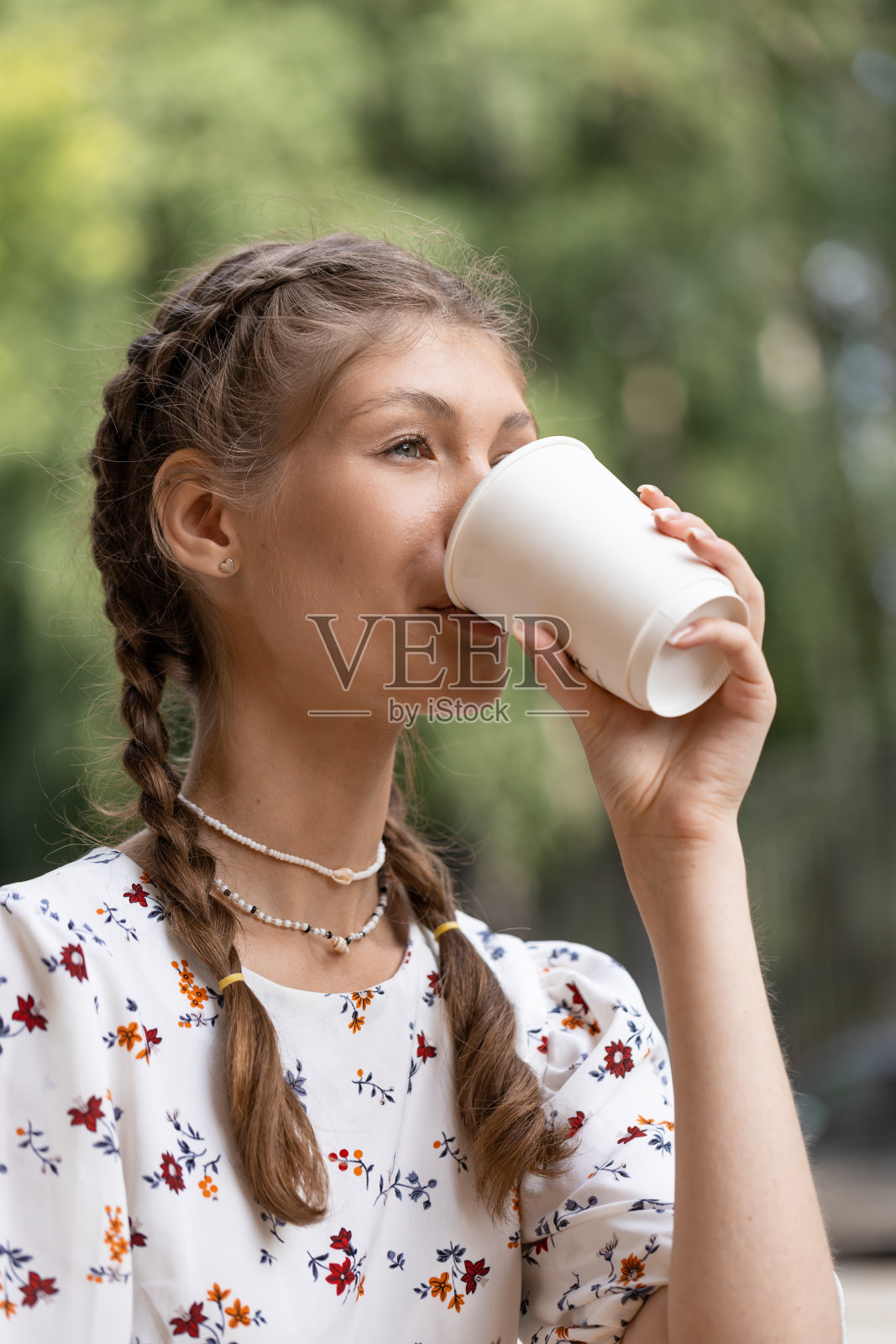 年轻漂亮的女孩喝着咖啡在城市里散步照片摄影图片