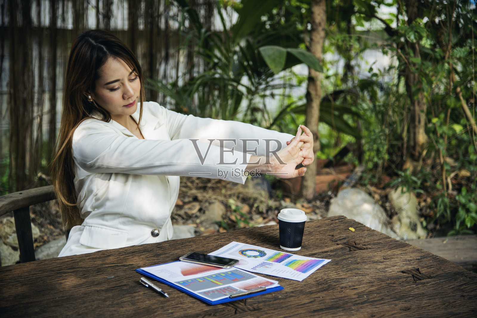 女士伸展手臂抬起坐姿不正确的家庭办公室办公桌。年轻的亚洲妇女背部疲劳的身体压力背部疼痛办公室综合症。女性在家工作新常态照片摄影图片