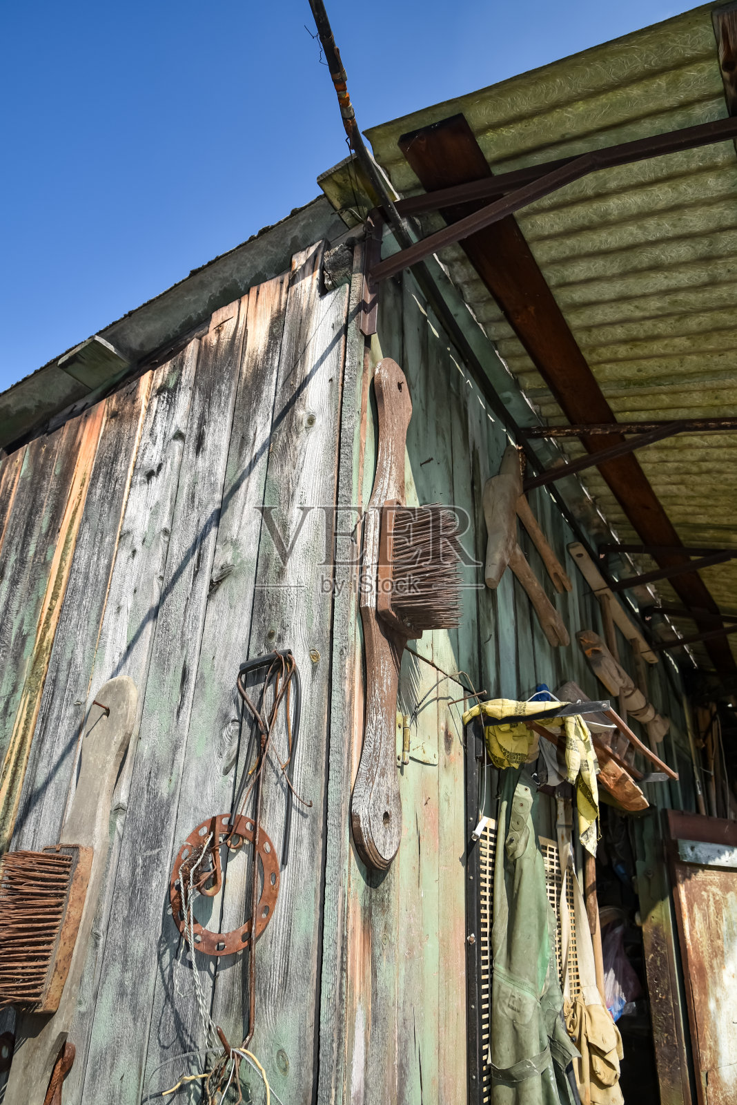 村里一间木屋的墙上挂着各种各样的工具照片摄影图片