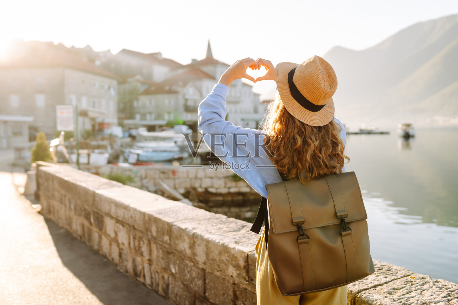 女游客用手制作心形，欣赏城市全景和著名地标照片摄影图片