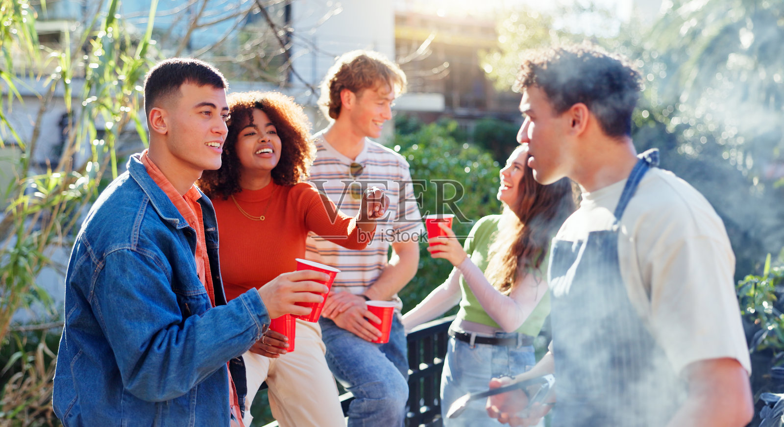 快乐的人，与朋友一起喝酒和烧烤，进行社交聚会，建立联系或户外讨论。一群年轻的学生或友好的社区在户外烧烤享受大自然的交谈照片摄影图片