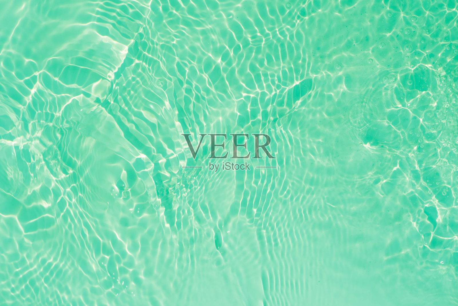 蓝蓝的水面上泛起涟漪。散焦模糊透明蓝色透明平静水面纹理与飞溅和气泡。水波与闪亮的图案纹理背景。照片摄影图片