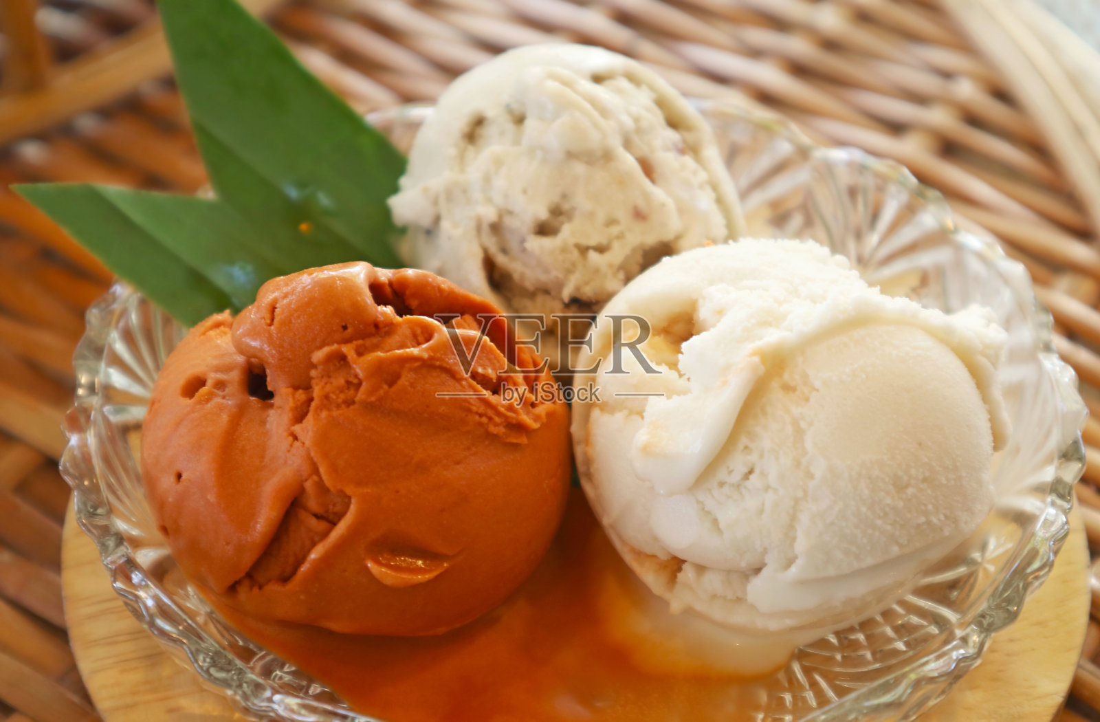 玻璃碗里三勺甜泰国茶和椰奶冰淇淋的特写照片摄影图片