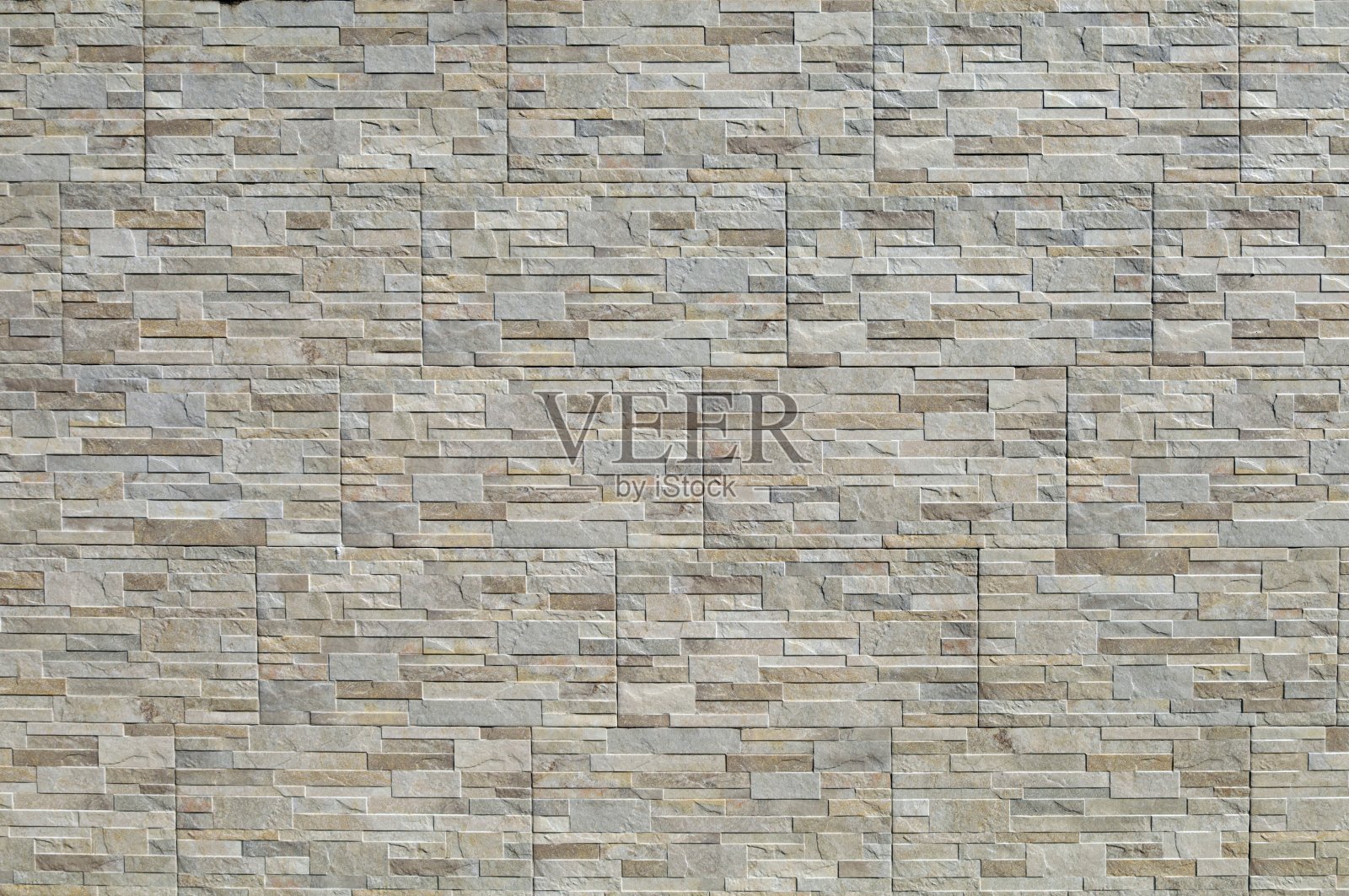 石材镶板墙，具有石材效果。颜色是深浅不一的棕色和灰色。外墙覆盖物照片摄影图片