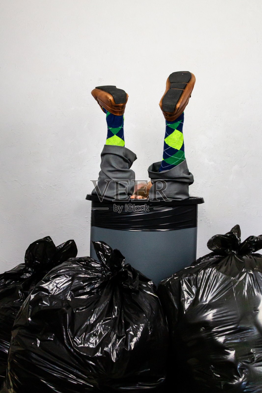 被塞进垃圾桶的商人照片摄影图片