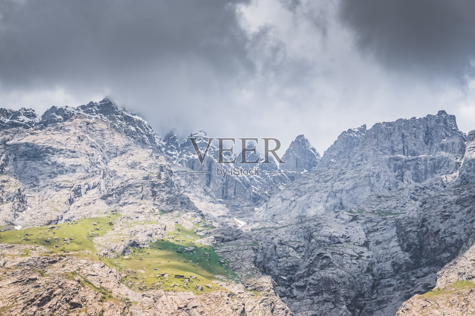 在天山山脉的一处岩石山脊上，在阴云密布的天气里，山峰的全景尽收眼底照片摄影图片