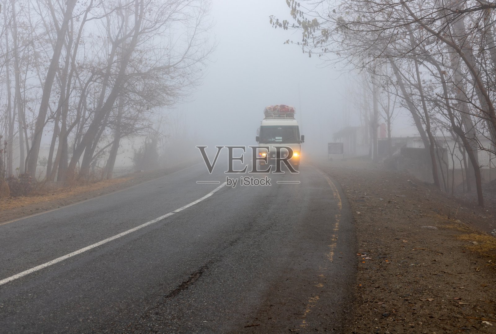 客车在巴基斯坦雾蒙蒙的道路上行驶照片摄影图片