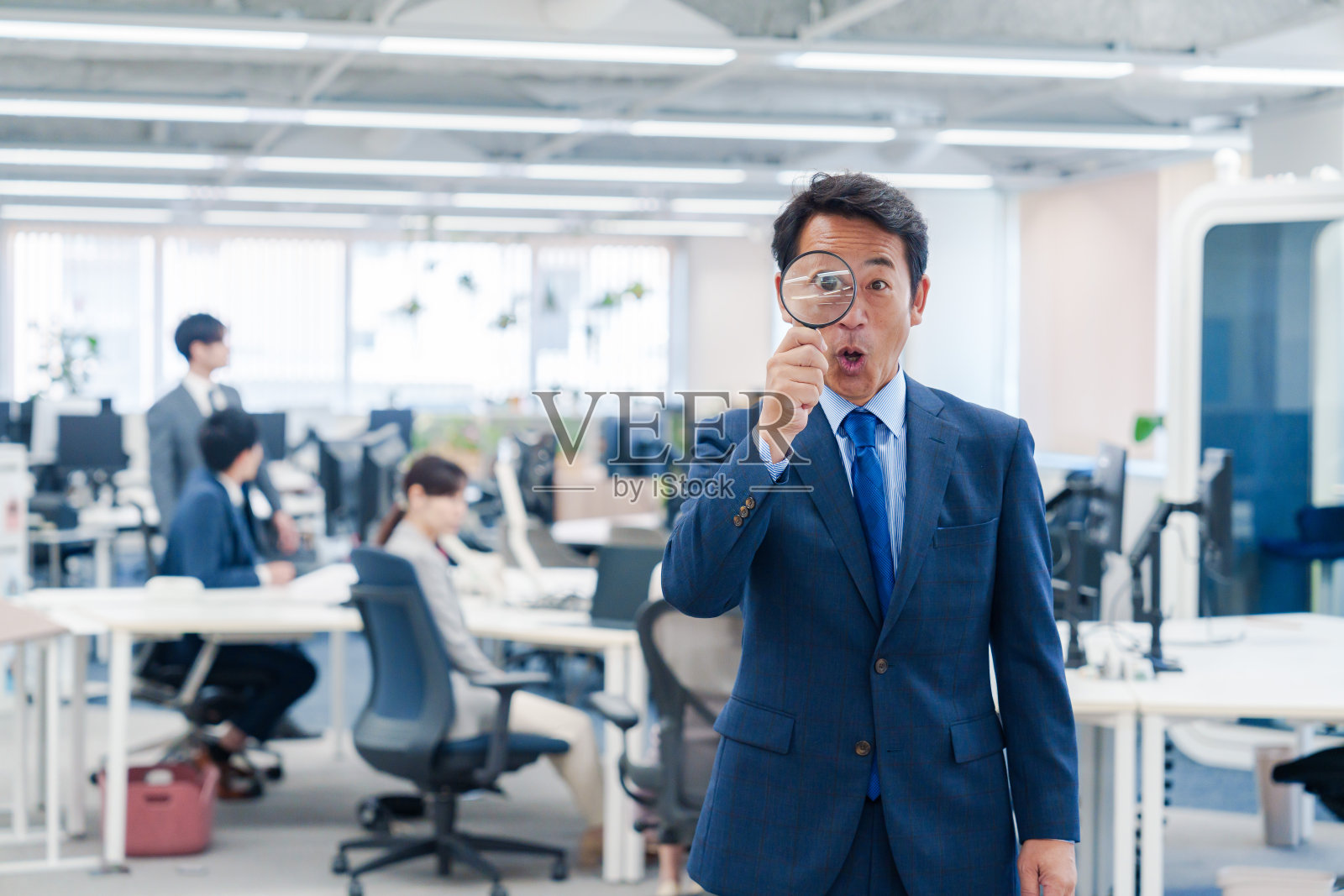 中年商人在办公室使用放大镜照片摄影图片