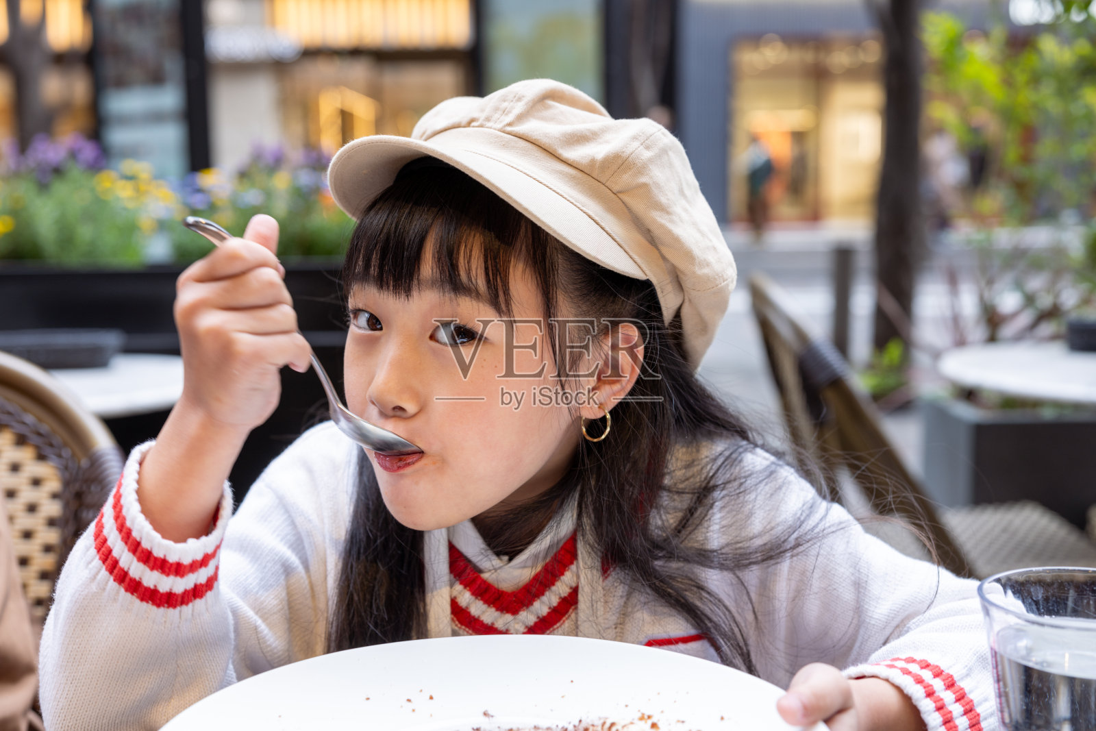 快乐的小女孩在户外咖啡馆吃甜点照片摄影图片