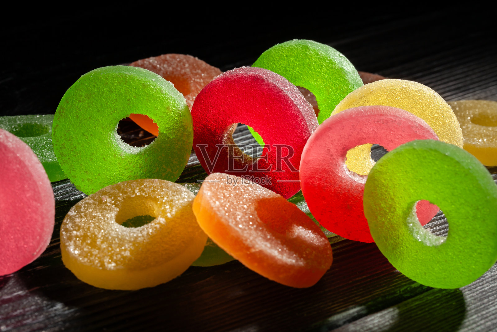 黑色木头上的果冻糖照片摄影图片