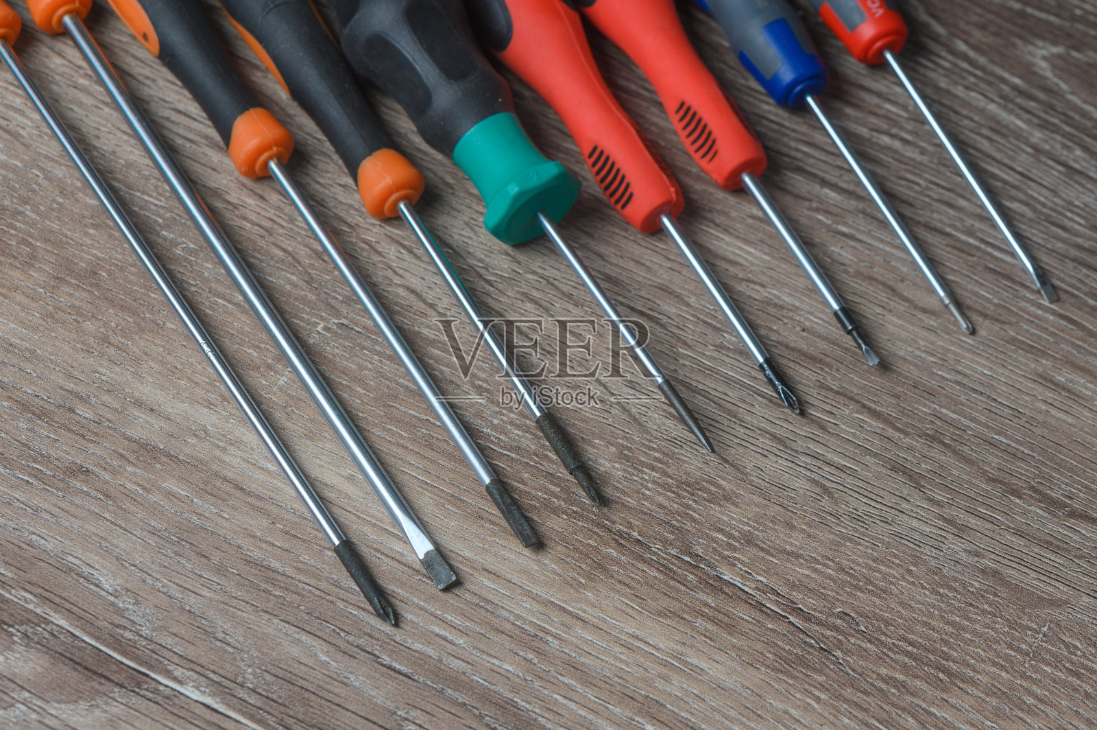 将螺丝刀和螺丝套在木桌上，平放。文本空间照片摄影图片