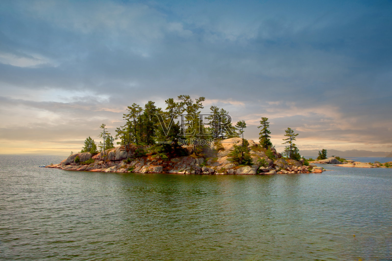 位于加拿大安大略省基拉尼省立公园清澈湖水中的偏远岛屿照片摄影图片