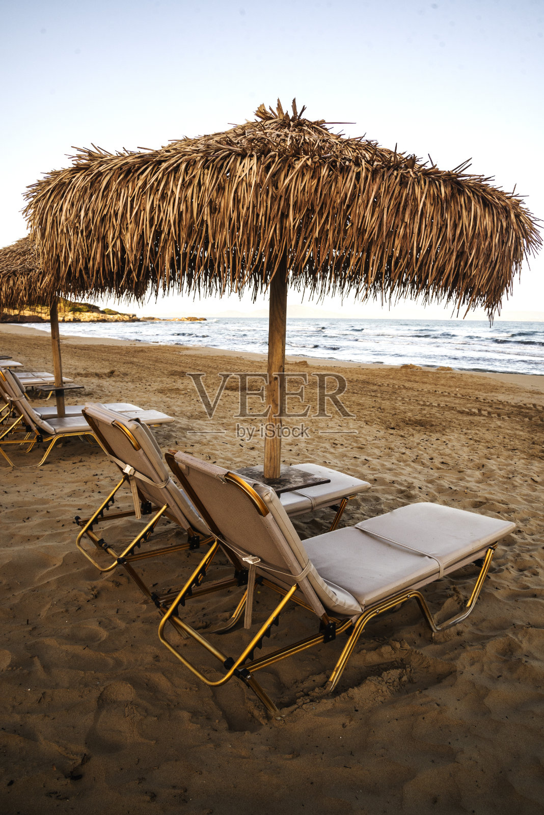 沙滩上的两把沙滩椅和一把雨伞照片摄影图片