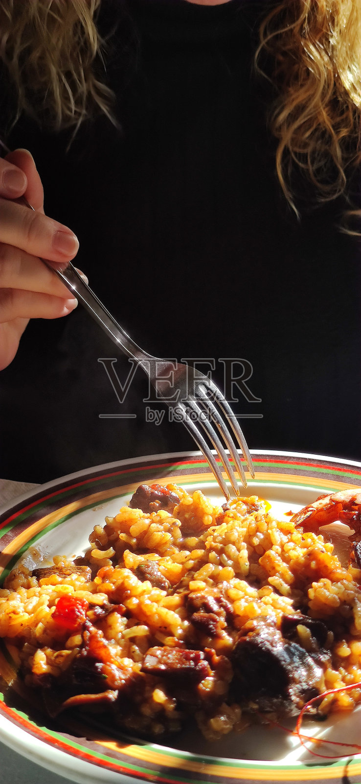 西班牙妇女吃海鲜饭照片摄影图片