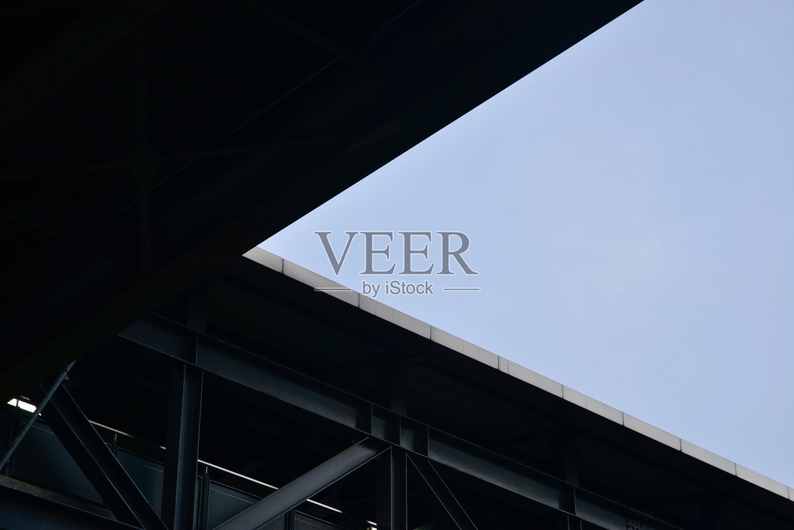 这是一个城市的场景，展示了一座现代桥梁的底部，湛蓝的天空。照片摄影图片