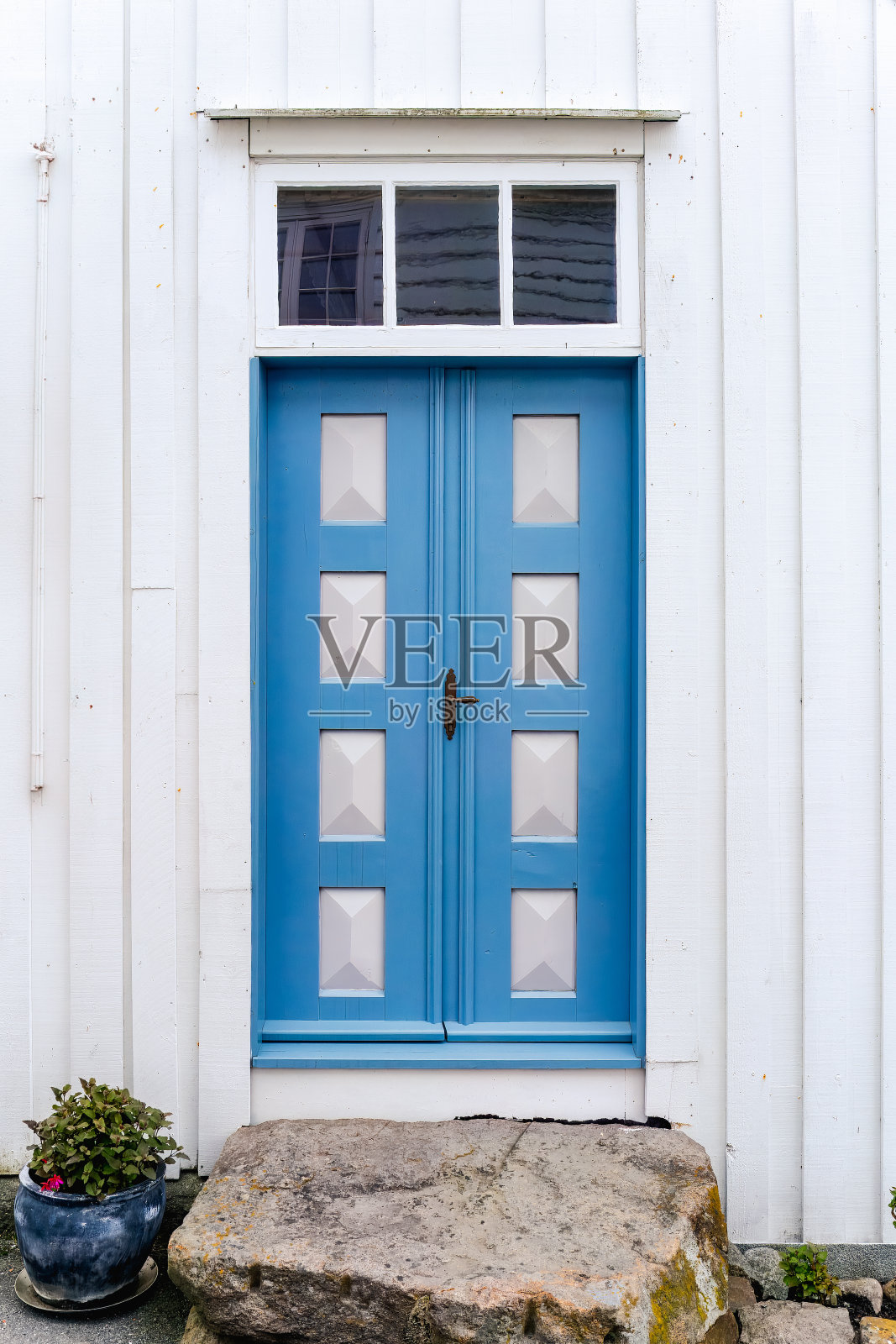 白色建筑里的蓝色木门。照片摄影图片