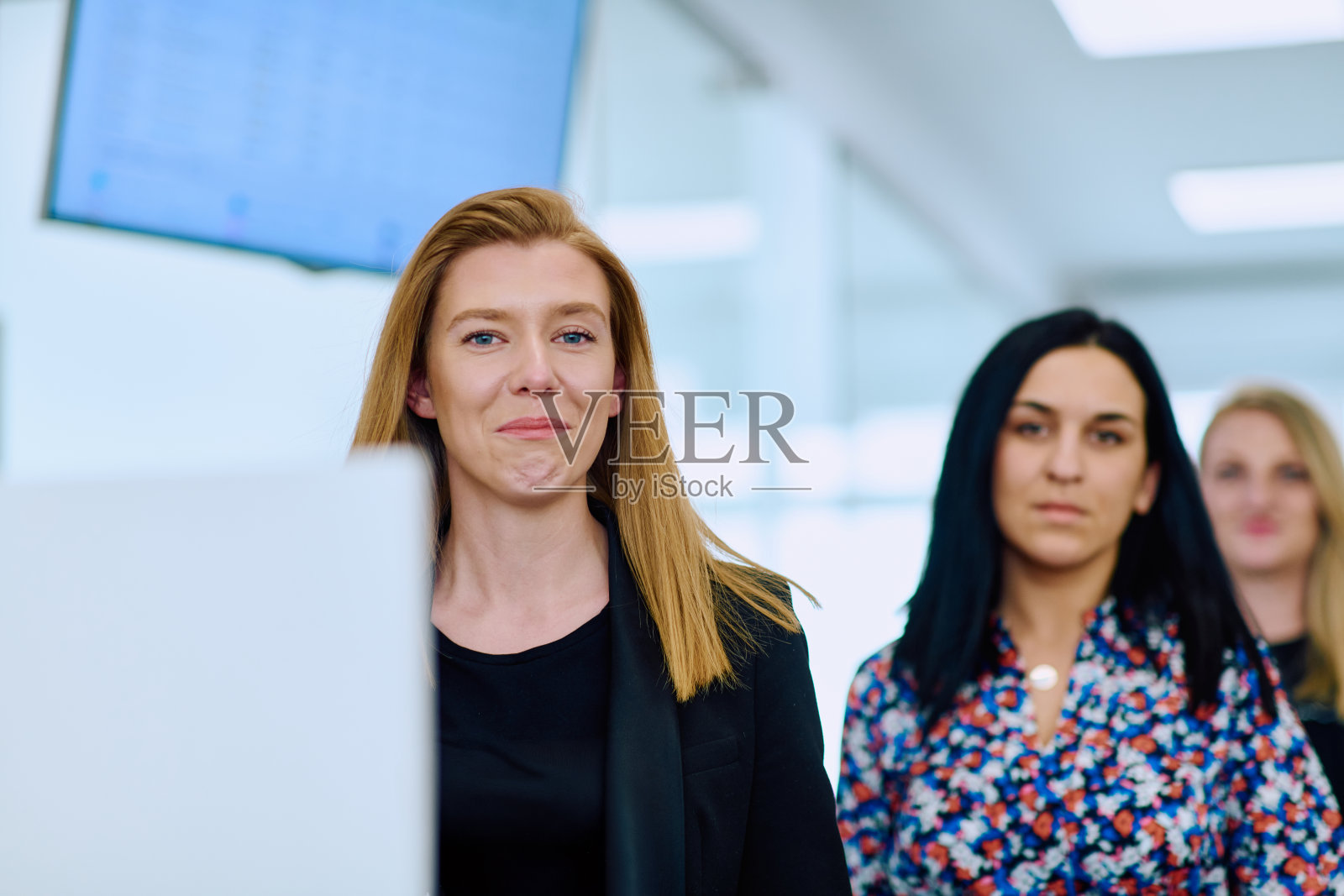 自信的女商人大步走过办公室走廊，深入讨论。照片摄影图片