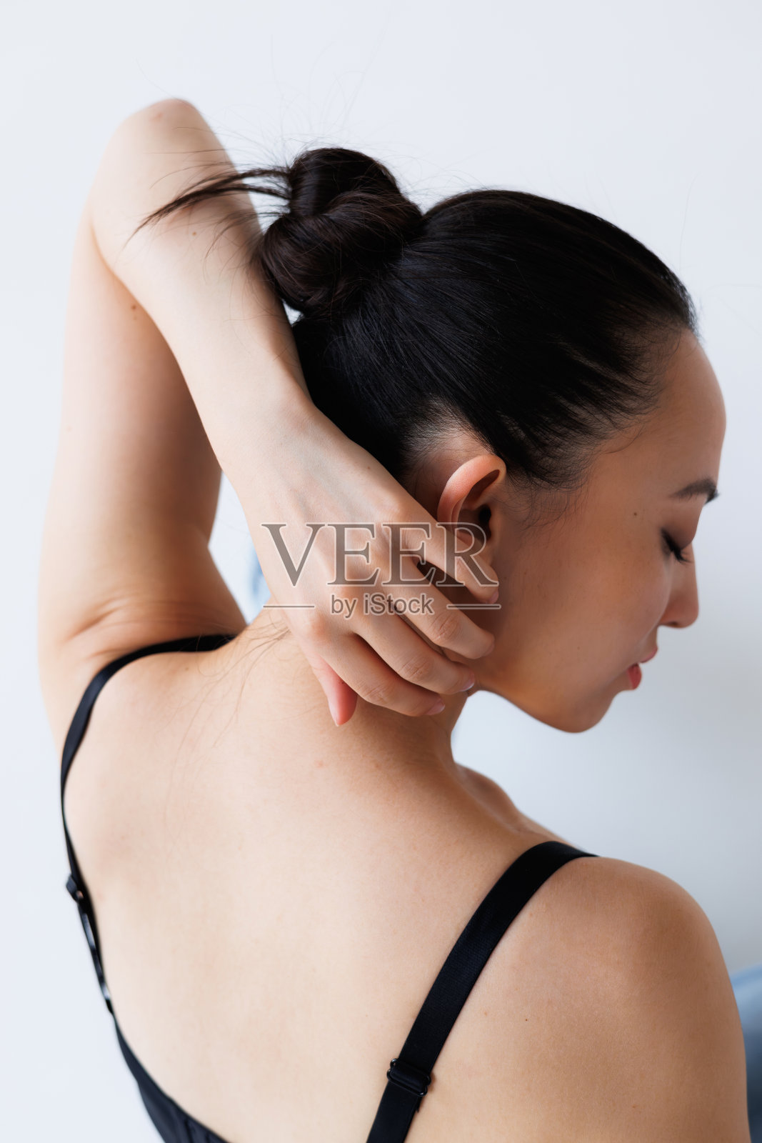 身穿紧身衣的亚洲女性在灰色背景上摆姿势照片摄影图片