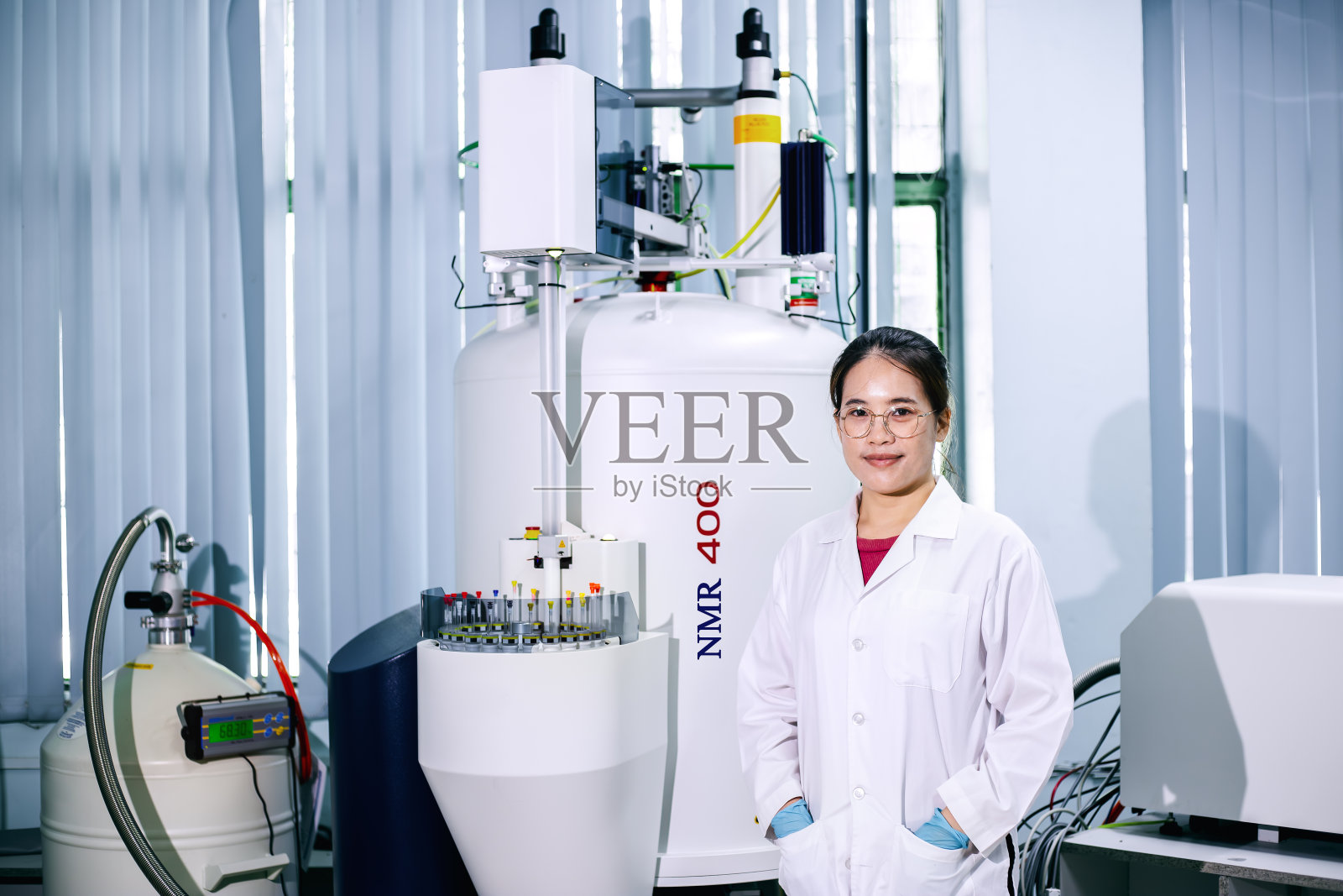 研究人员肖像与核磁共振光谱仪器(NMR) 400兆赫在实验室。照片摄影图片