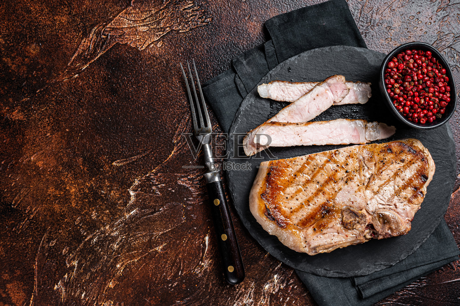 烤烧烤猪排或丁骨肉牛排切在板上。黑暗的背景。前视图。本空间照片摄影图片