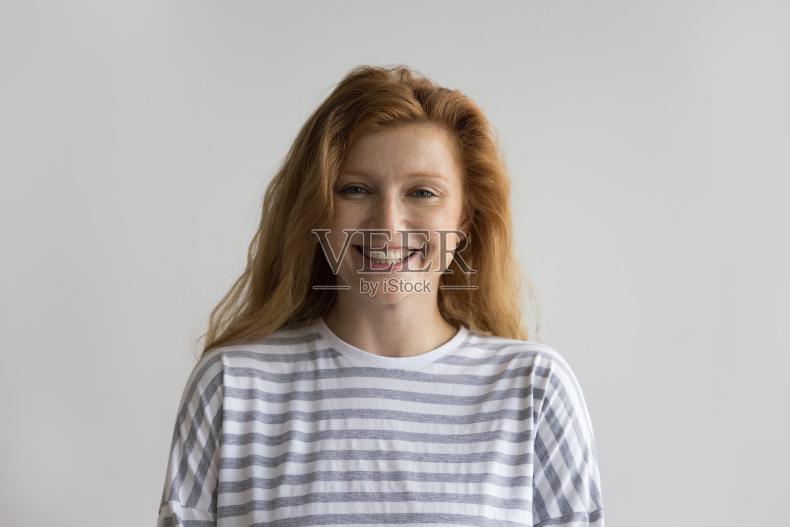 快乐的千禧红发女人笑着看着镜头照片摄影图片