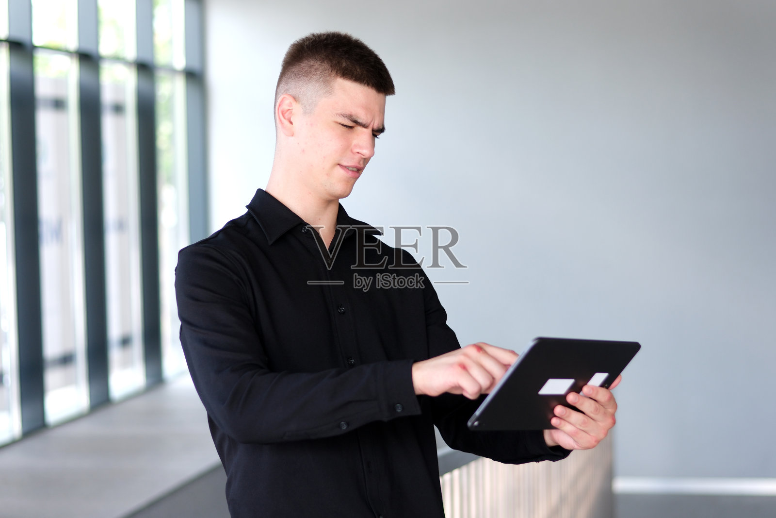 一个手骨折的人在打架后手里拿着一个平板电脑照片摄影图片