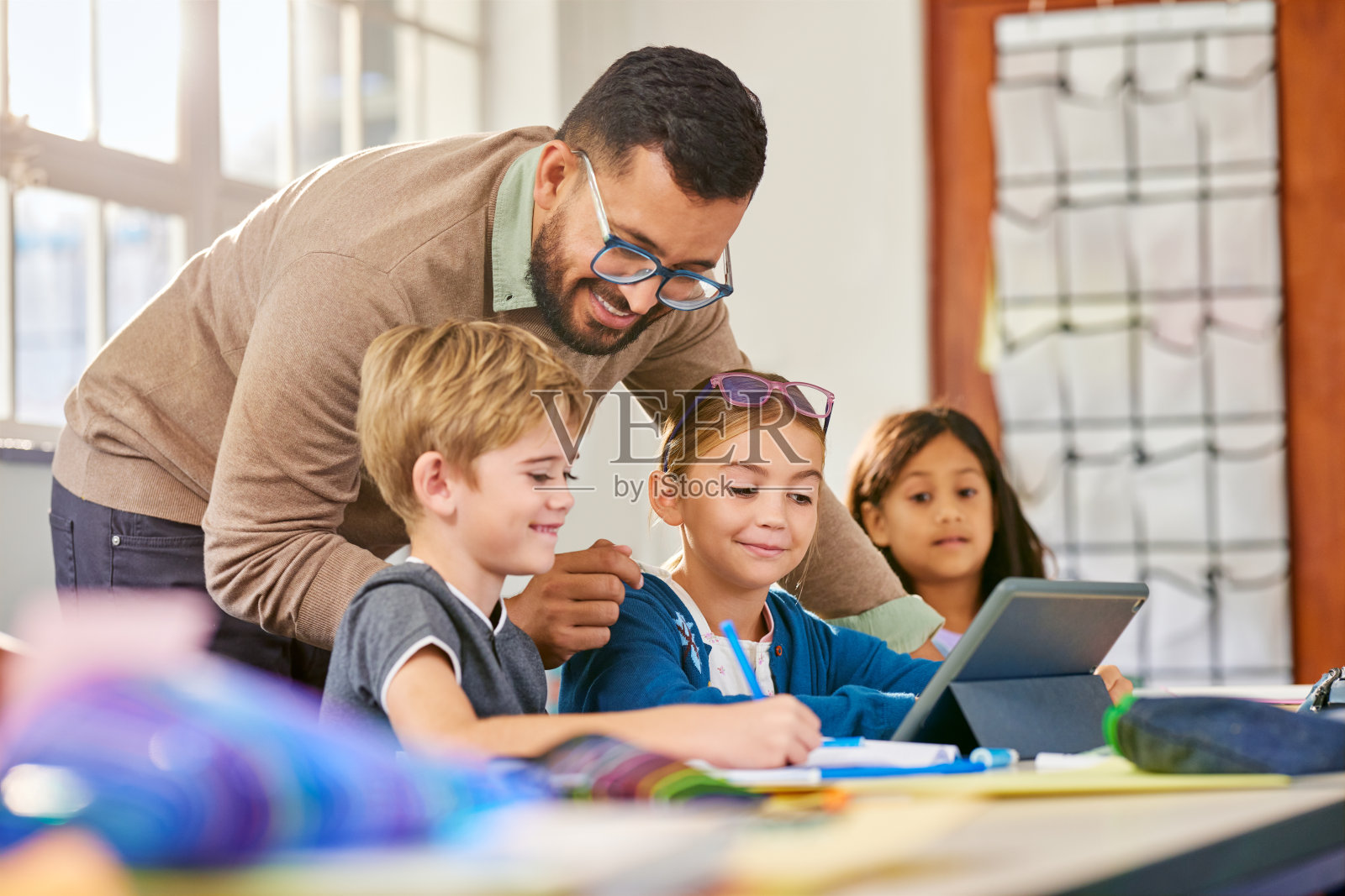 在老师的帮助下，小学生使用平板电脑照片摄影图片