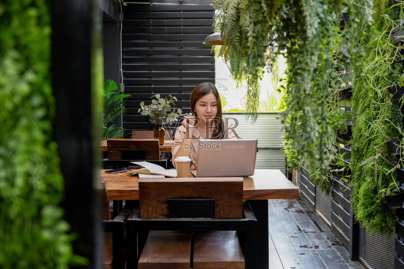 一位女商人正在通过笔记本电脑与她的团队进行在线会议。哪一款可以在咖啡店远程在线会议照片摄影图片