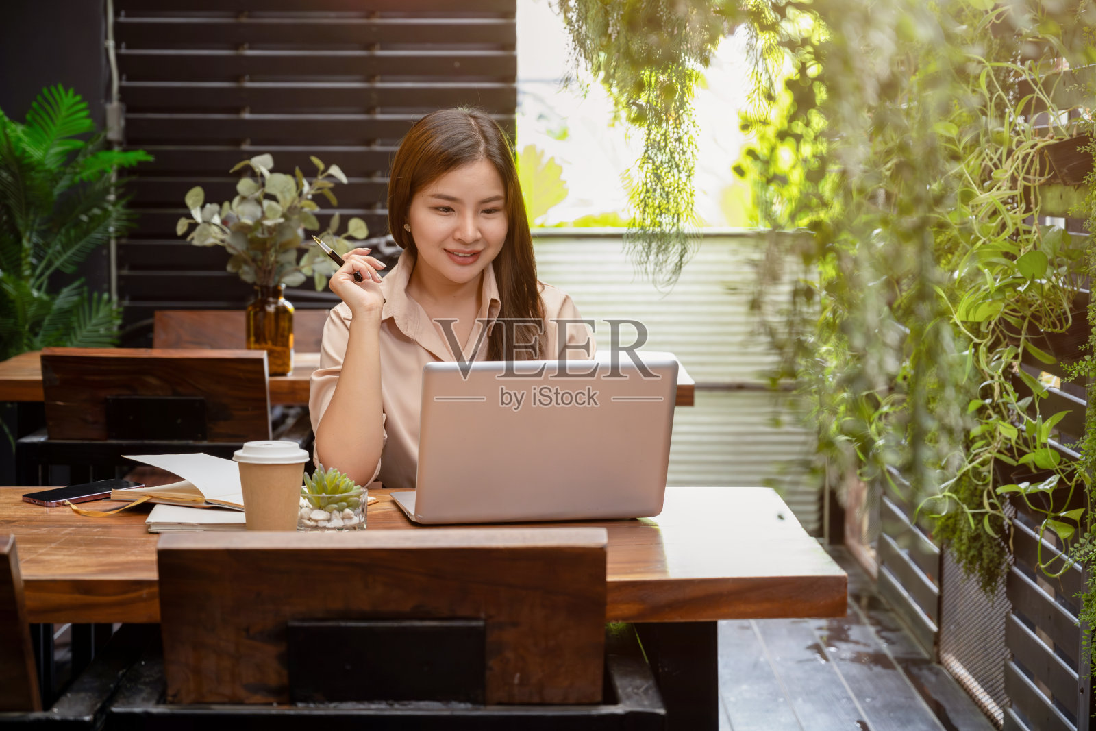 一位女商人正在通过笔记本电脑与她的团队进行在线会议。哪一款可以在咖啡店远程在线会议照片摄影图片