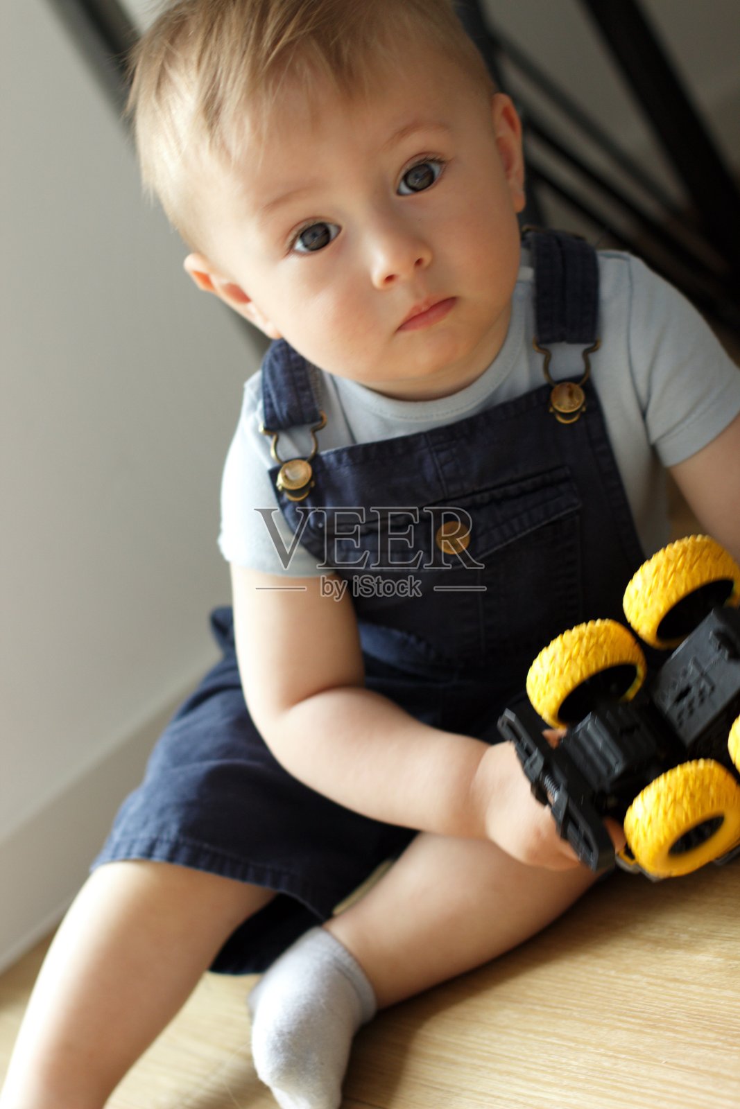 一个小孩坐在窗边玩玩具车照片摄影图片