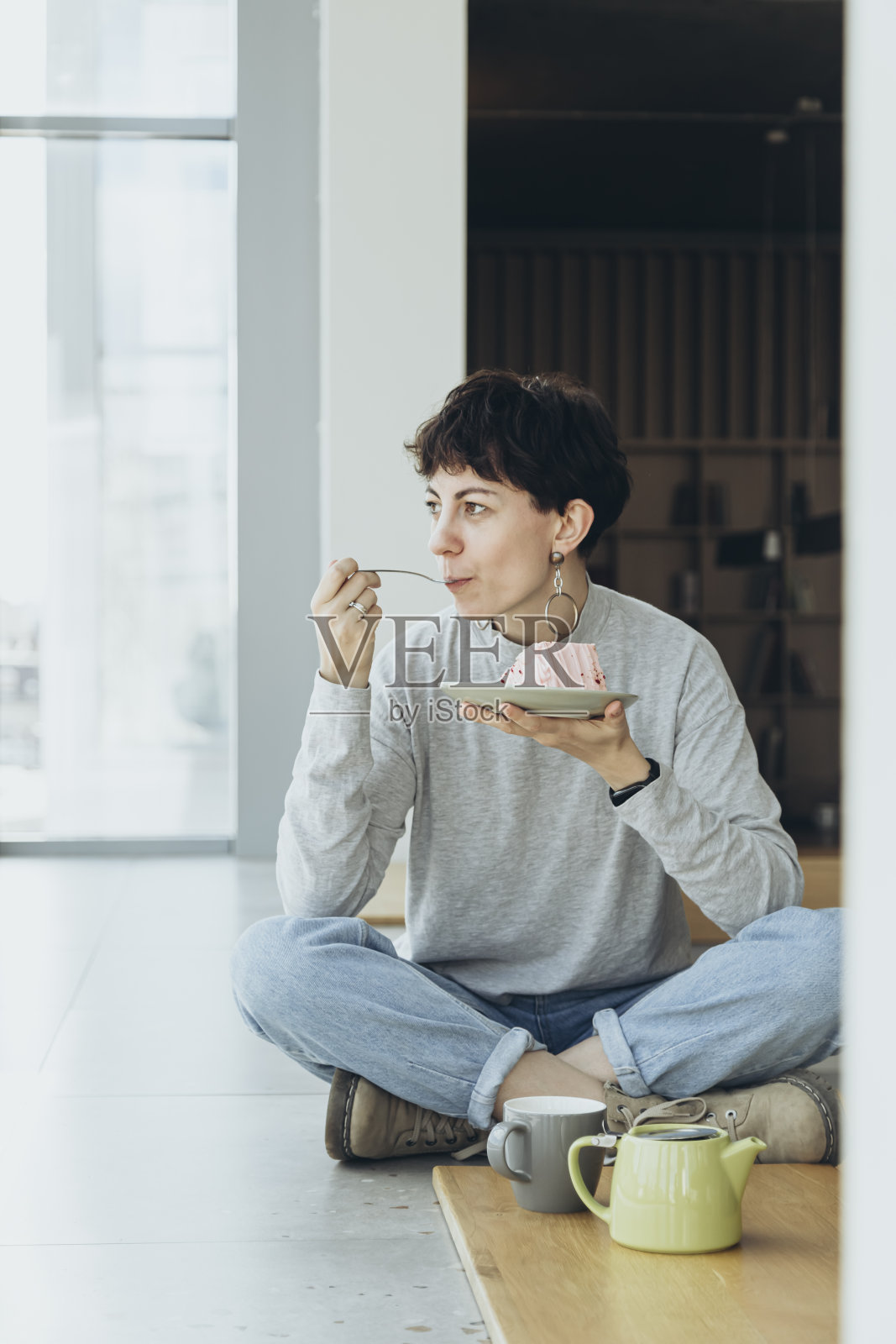 时尚女子在现代咖啡馆享用一块蛋糕。照片摄影图片