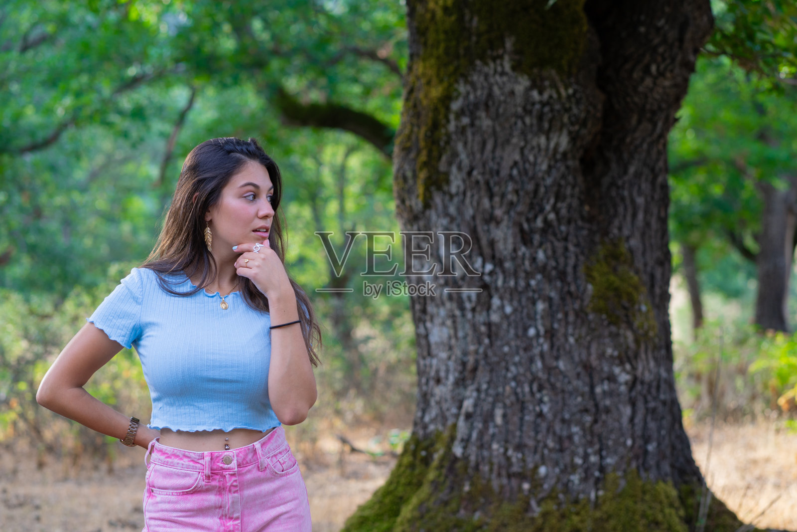 森林里站在树旁的女人照片摄影图片