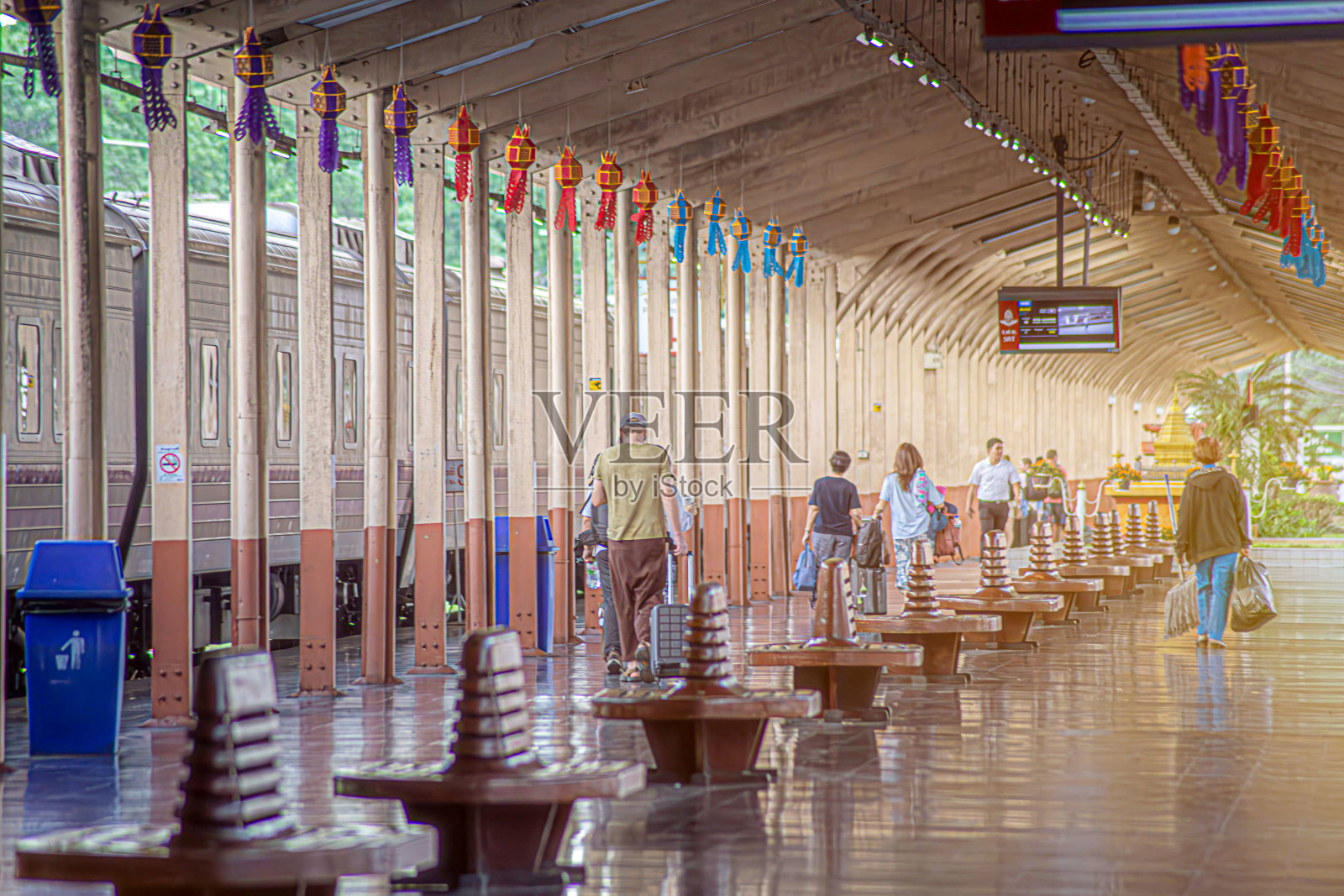 旅客在火车站站台上背着背包和随身物品。照片摄影图片