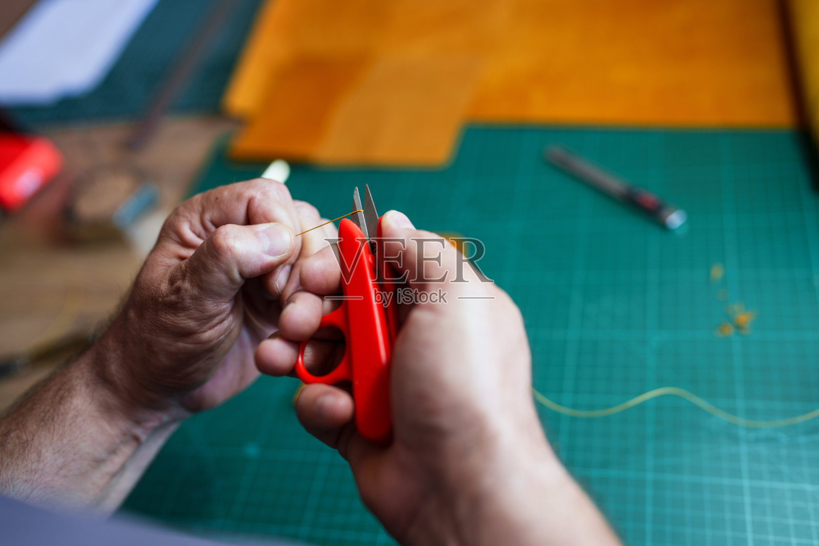 男子用小剪刀剪绳子。照片摄影图片