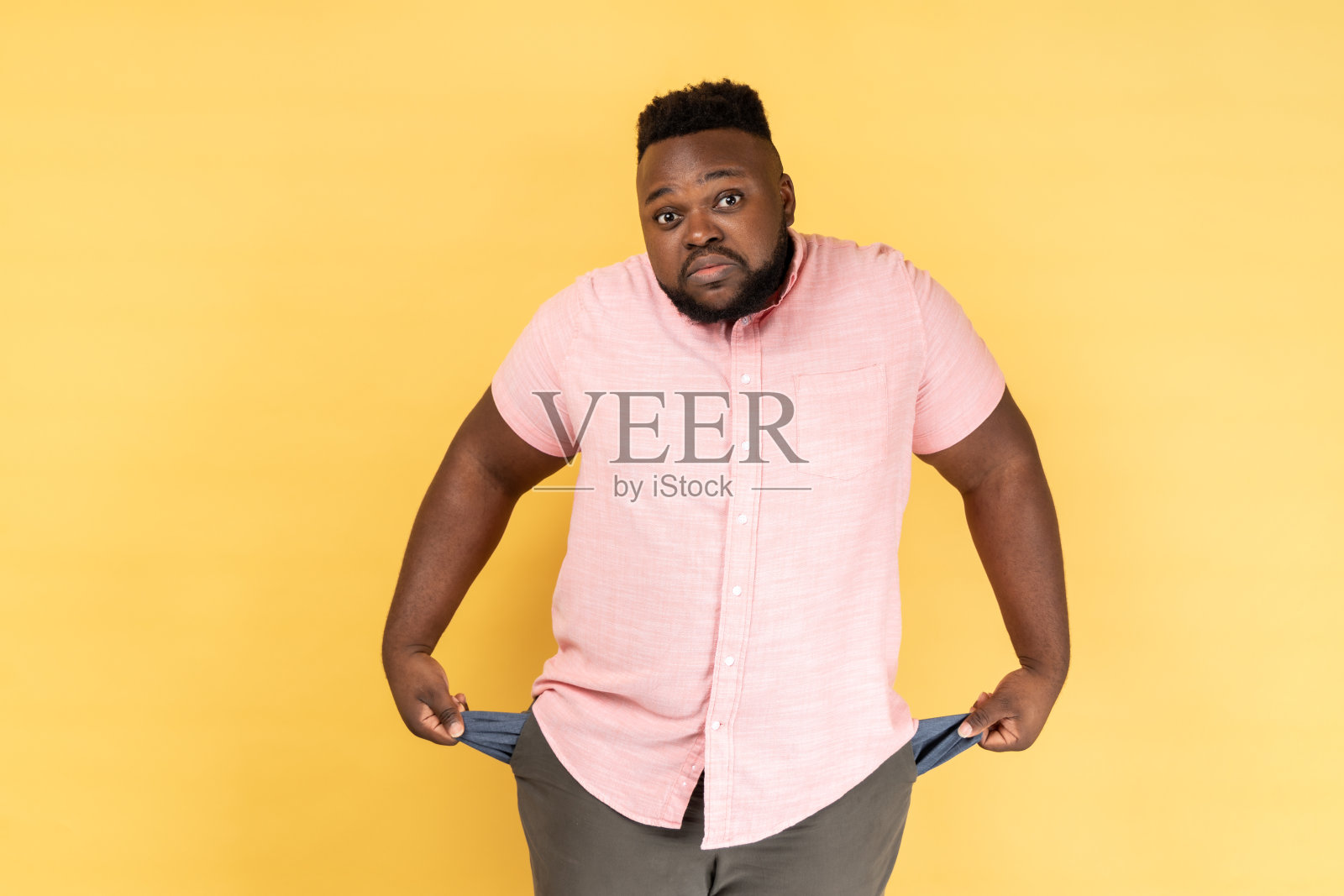 男人翻出空口袋，示意没钱，面露愁容照片摄影图片