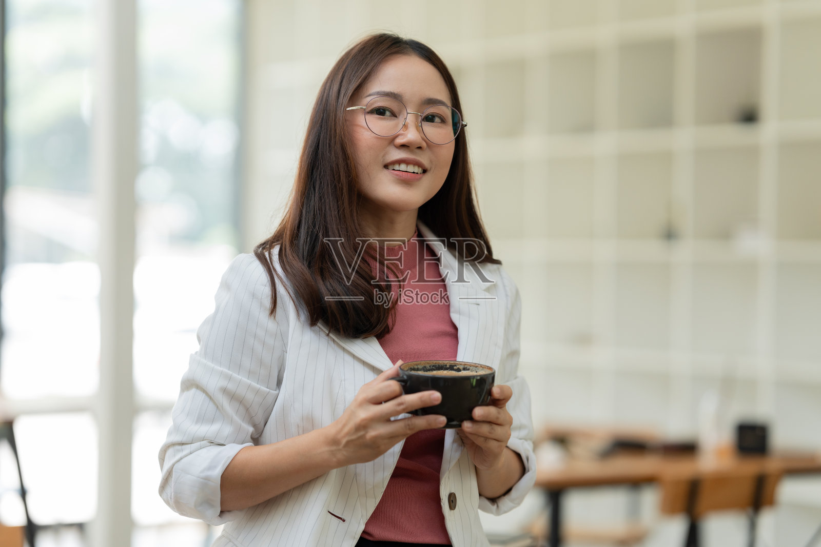 坐在咖啡馆里工作和喝咖啡的亚洲妇女照片摄影图片