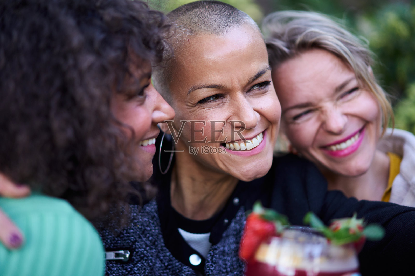 近距离拍摄三位美丽微笑的中年多元文化女性，她们在户外自拍。照片摄影图片