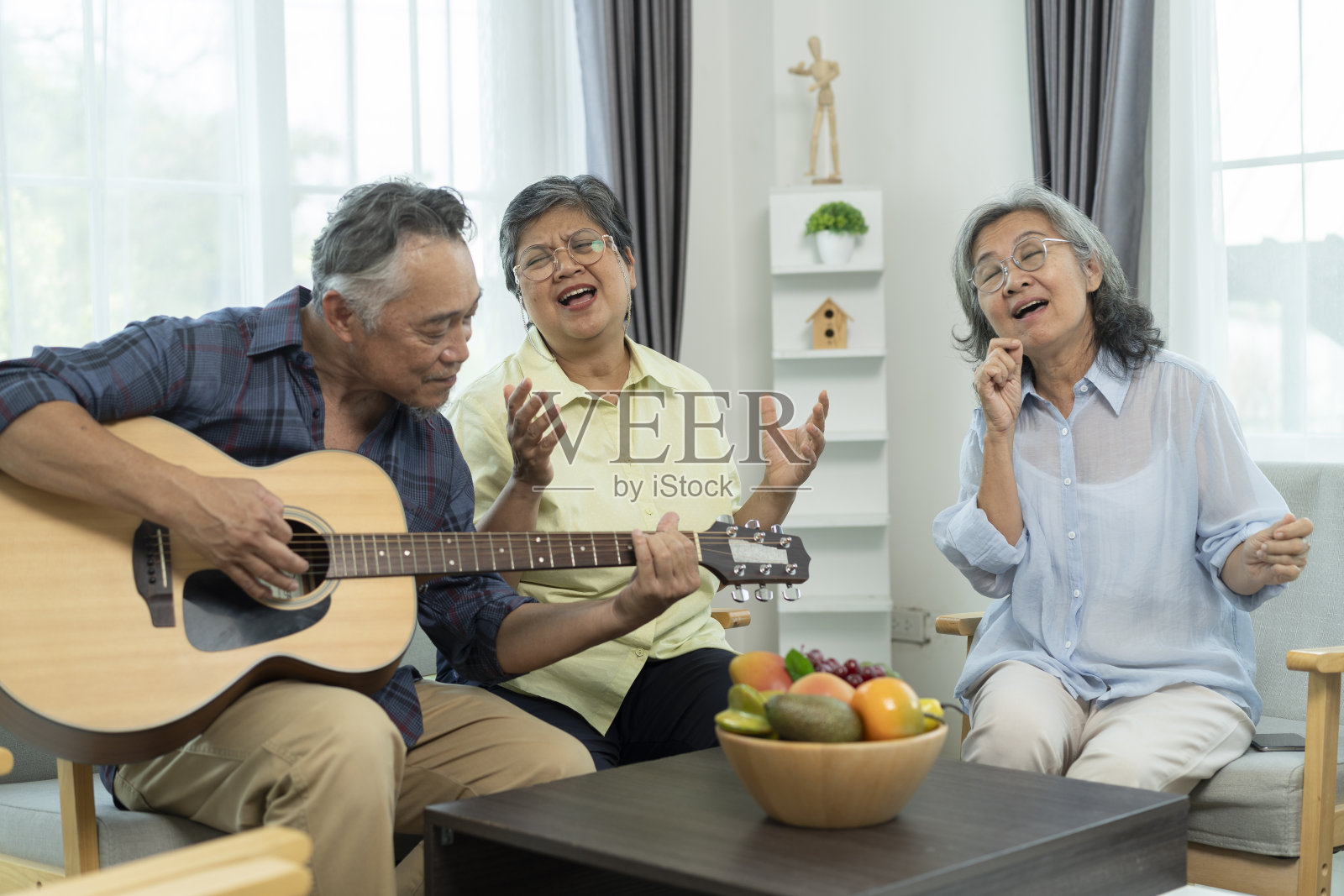 快乐的退休亚洲朋友在客厅一起唱歌和弹吉他照片摄影图片