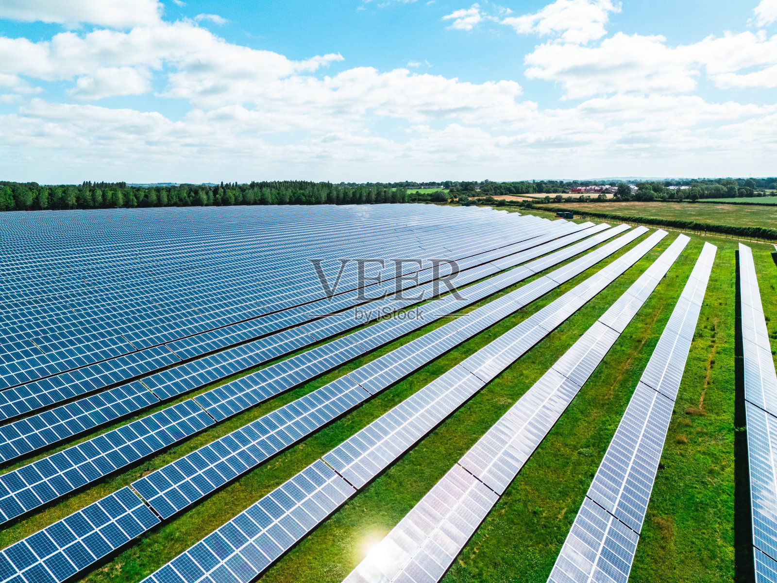 阳光明媚的日子里，郊区绿地上的太阳能电池板鸟瞰图照片摄影图片