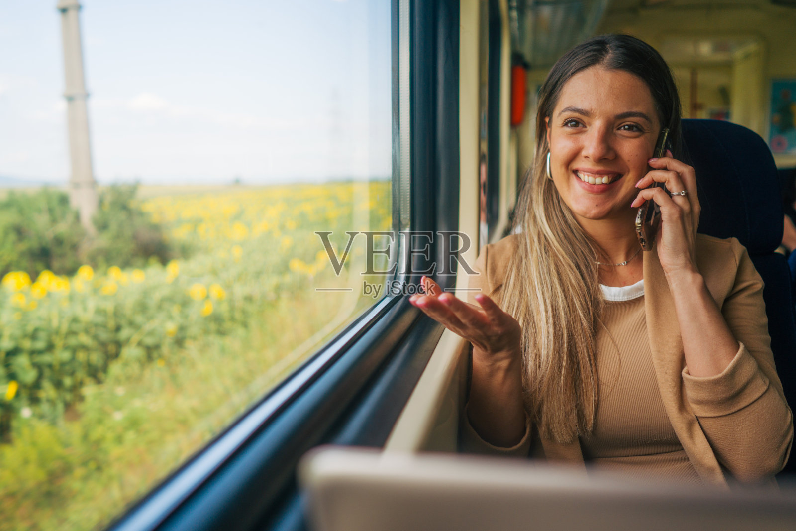 年轻女子乘火车旅行，使用笔记本电脑和手机照片摄影图片