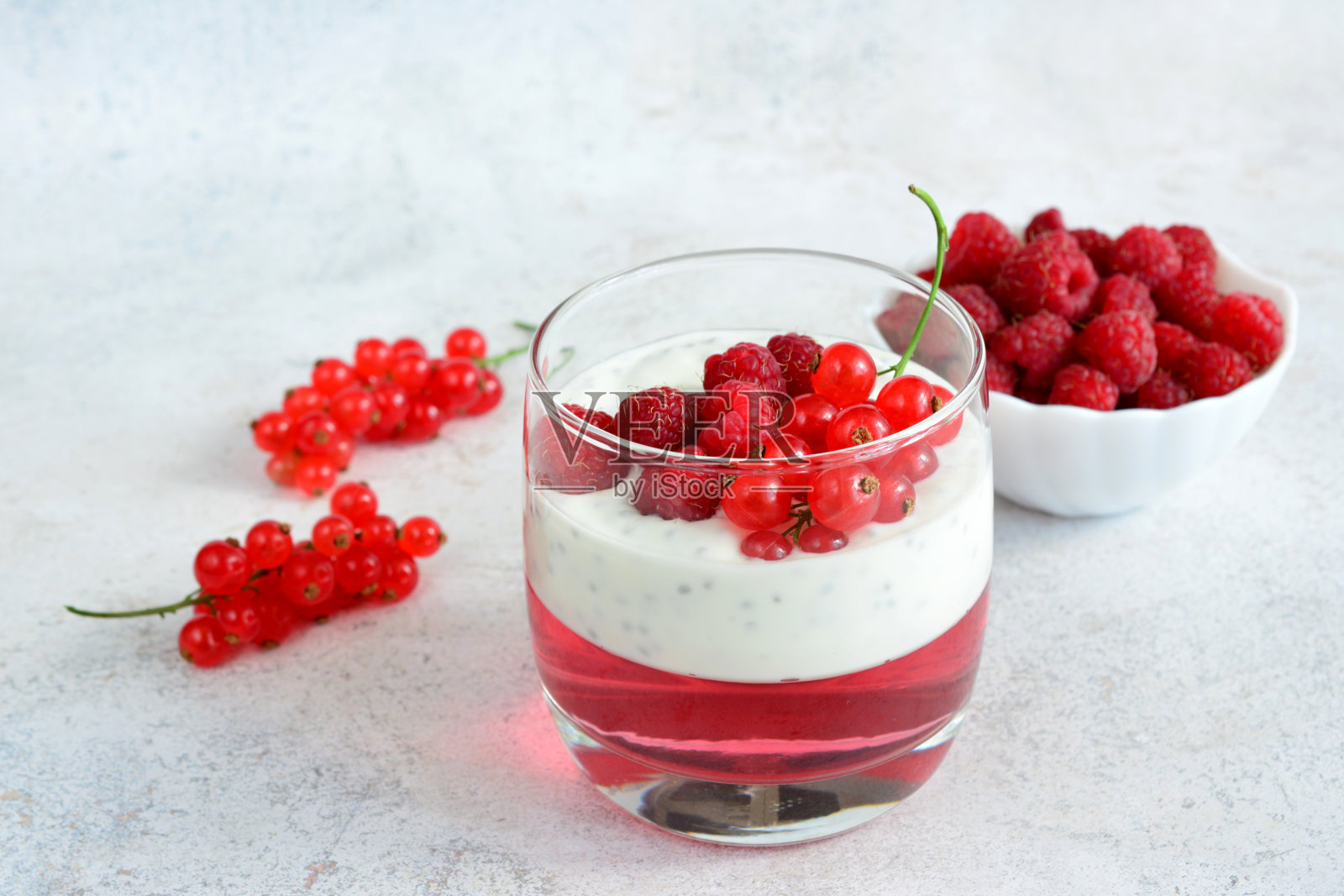 一杯红醋栗酸奶和一碗覆盆子照片摄影图片
