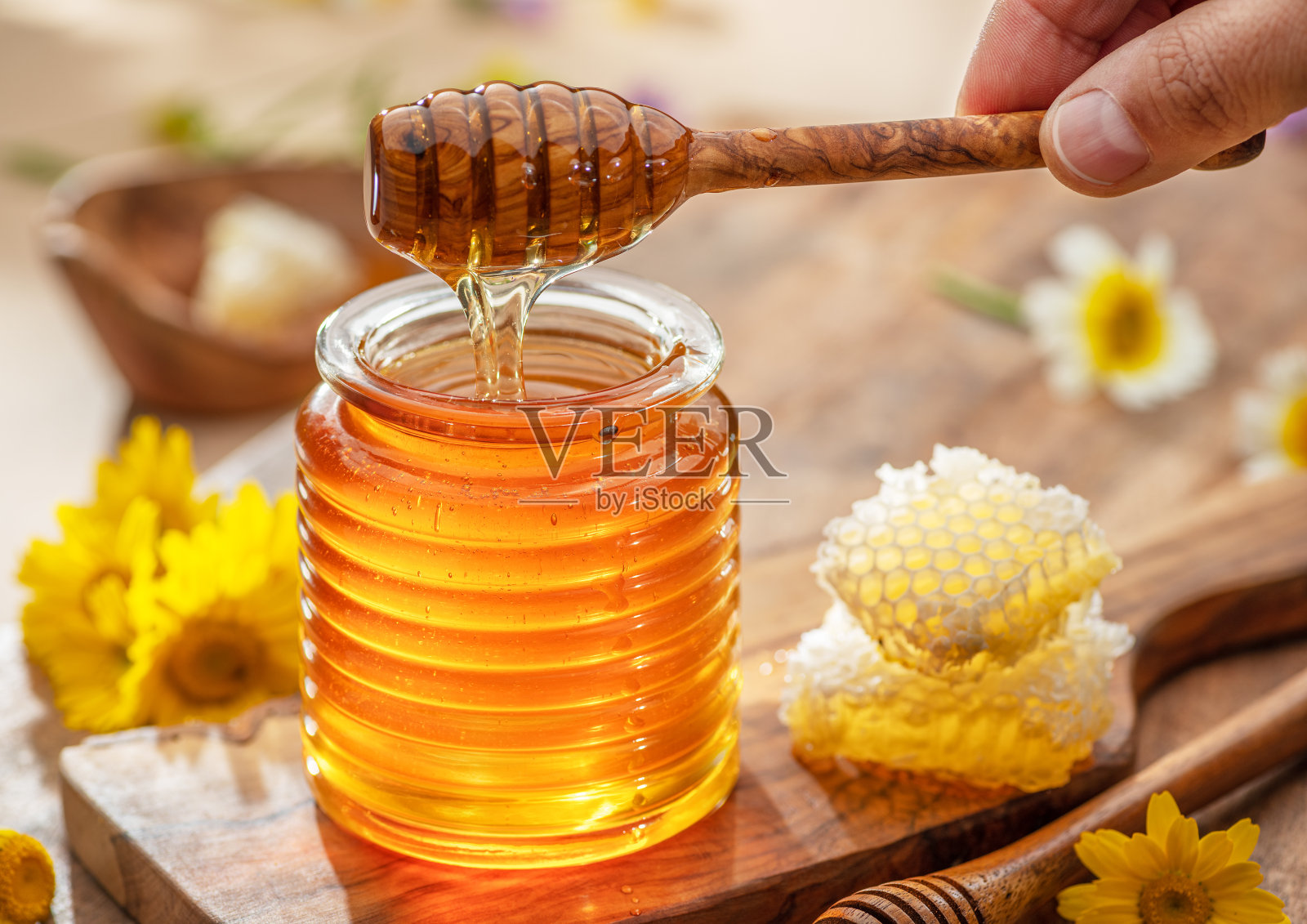 天然有机蜂蜜在玻璃罐，蜜罐和蜂窝附近。天然食物背景。照片摄影图片