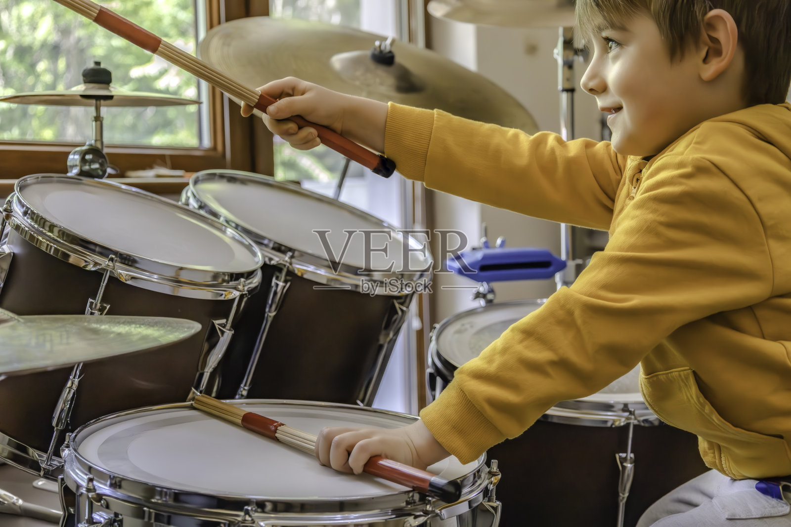 一个快乐的小孩在打鼓照片摄影图片